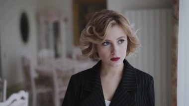 Lüks bir evde kameraya poz veren düşünceli bir kadının portresi.