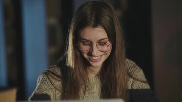 Heureuse jeune fille se réjouit et les mains en l'air lorsque vous travaillez avec un ordinateur portable dans la bibliothèque — Video