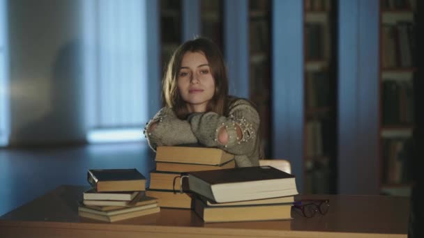 Portrait of cute student leaning on books at desk and smile at camera — Stok Video