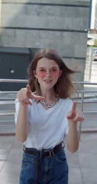 Kameranın önünde dans eden şık görünümlü kızın dikey yakın görüntüsü.