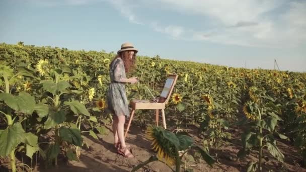 Vista colorida de la pintura de señora de pelo largo bastante en el campo de girasol — Vídeos de Stock