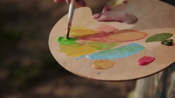 Vista cercana de la mezcla de acuarelas en paleta de madera — Vídeos de Stock