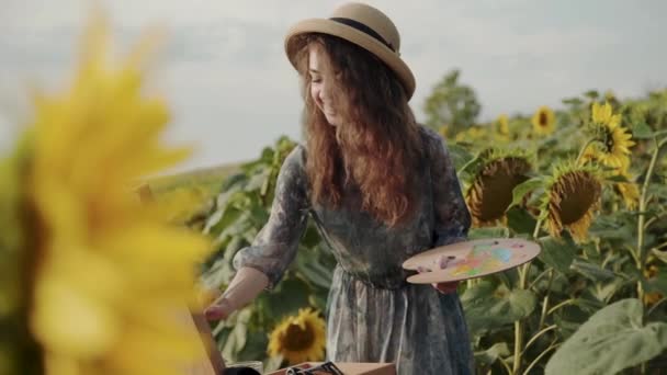 Счастливая дама рисует среди красивых подсолнухов с летящей пчелой — стоковое видео