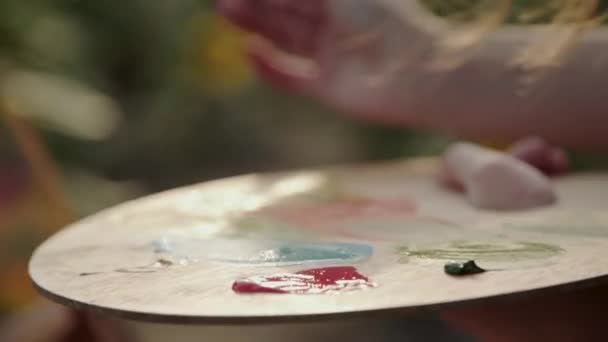 Close view of mixing a watercolors on wooden palette on nature — Stock Video