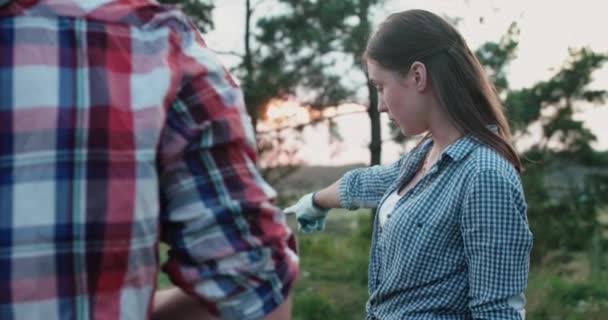 Młoda dziewczyna wyjaśnia pracowników gestami i bierze worek na śmieci na przyrodę — Wideo stockowe