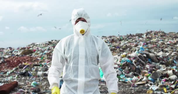 Portrait de l'écologiste en costume de protection croise les mains à la terre polluée — Video