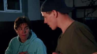 Karanlık bir spor salonunda boksör ve koç eğitimi. Koçla birlikte erkek kickboxer trenleri. Erkekler antrenman yapıyor. Dövüş sporu kavramı.