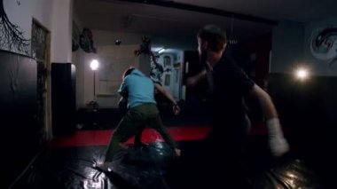 Spor salonunda üç erkek dublörün dövüş sahnesi. Erkekler yavaş çekimde karanlık spor salonunda boks hareketlerini geliştirir. Genç erkekler içeride antrenman yapıyor..
