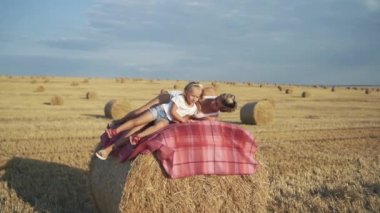 Mutlu bir aile, güneşli bir günde samanlıkta rahatlıyor.