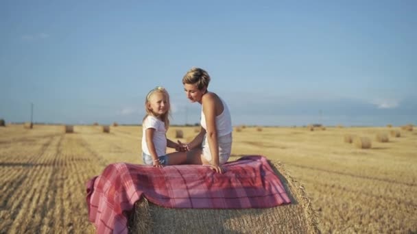 Familia feliz hablando en un pajar en un día soleado en el campo — Vídeos de Stock