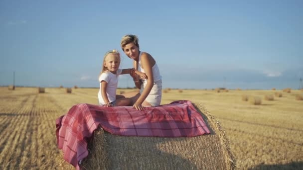 Madre feliz con hija divirtiéndose en un pajar en un día soleado en el campo — Vídeos de Stock