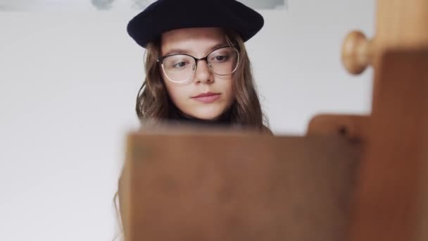 艺术工作室画布上贝雷帽绘画画中年轻女艺术家的近照 — 图库视频影像