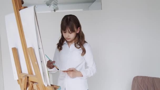 Easel, School kid in Workshop Class 의 어린이 그림그리기. 교실에서 미술 공예를 하고 있는 소녀 — 비디오