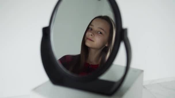 Ragazza con i capelli scuri in uno specchio nero, sorridente — Video Stock