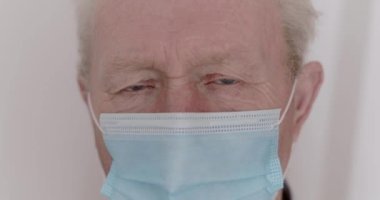 Üzücü bir şekilde kameraya bakıyor ve büyükbabanın maskesinde karantinaya alınıyor.