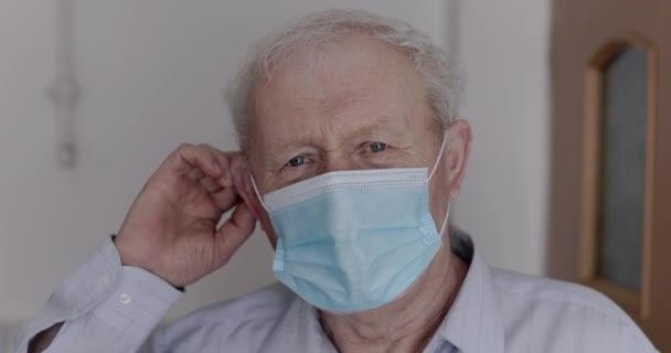 Un uomo anziano e guarito toglie una maschera medica e si rallegra sinceramente della macchina fotografica — Video Stock