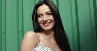 Dışarıda kamerayla oynayan neşeli bir kadının portresi.