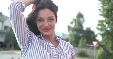 Gülümseyen ve saçlarını düzelten mutlu bir kız.