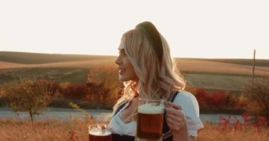 Slav, etnik giysili ayyaş kız kameraya iki bira bardağıyla poz veriyor.