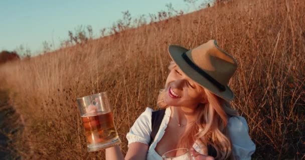 Attraente ragazza slava in abito e cappello ammira pinte di birra chiara e scura — Video Stock