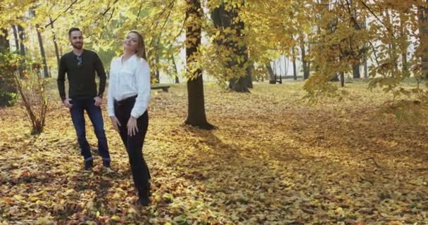 Ευτυχισμένο ζευγάρι στέκεται σε στάσεις το φθινόπωρο ηλιόλουστο πάρκο, κορίτσι γυρίζει πίσω στον άντρα της — Αρχείο Βίντεο