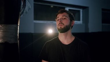 Yakışıklı, beyaz bir gencin, yüzünü kameraya çevirip karanlık salonda kurnaz bakışlarının portresi. Karanlığın içinde ciddi yüzlü çekici bir erkeğe yaklaş..