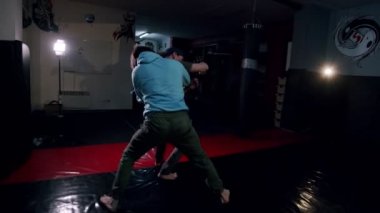 Spor salonunda üç erkek dublörün dövüş sahnesi. Erkekler yavaş çekimde karanlık spor salonunda boks hareketlerini geliştirir. Genç erkekler içeride antrenman yapıyor..
