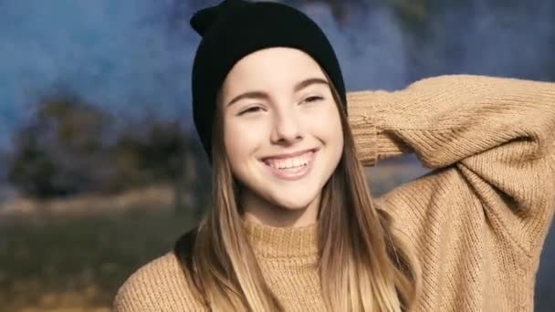 Retrato de una chica inteligente sonriendo al cielo soleado en el parque usando coloridos fuegos — Vídeo de stock
