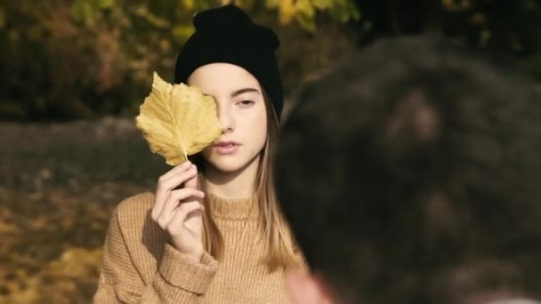 Junge Teenagerin posiert bei Fotosession mit Herbstblatt vor der Kamera — Stockvideo