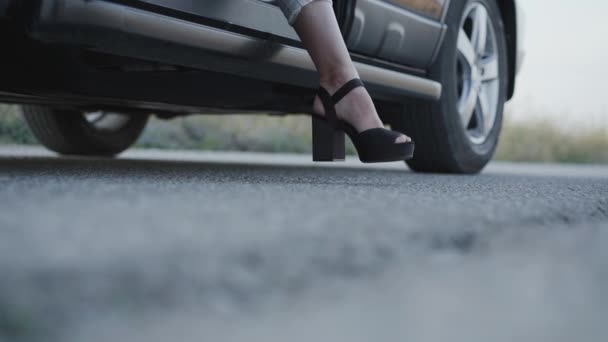 Nízký pohled na ženské nohy v botách s vysokými podpatky dostat ven z auta — Stock video