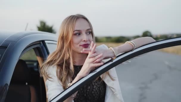 Mutlu kız dikiliyor ve otoyolda arabaya gülümsüyor — Stok video