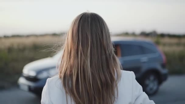 Счастливая дама ходит и позирует возле машины на камеру за городом — стоковое видео