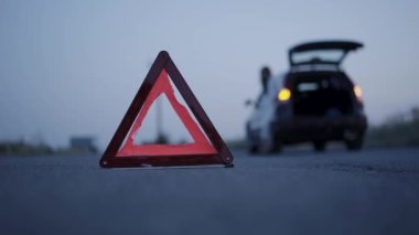 Bulanık arkaplan önündeki yol üzerindeki üçgen işaretinin akşam görünümü