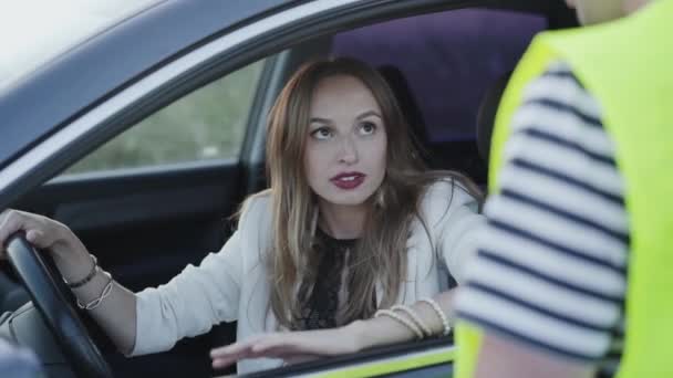 Ділова леді розмовляє з чоловіком в уніформі через вікно автомобіля — стокове відео