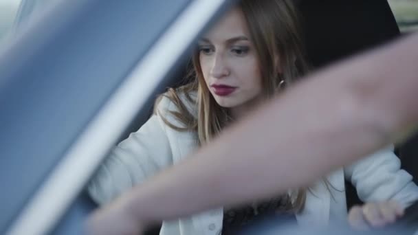 Vrouw in een auto knikt een hoofd van iemand uitleggen auto mechanica — Stockvideo