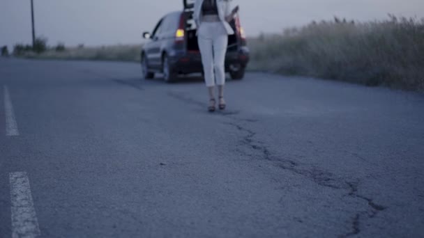 View of beautiful business lady walks and puts a road sign on highway — Stock Video