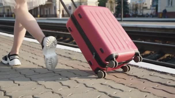 Blick auf weibliche Beine, die mit Koffer auf Bahnsteig gehen — Stockvideo