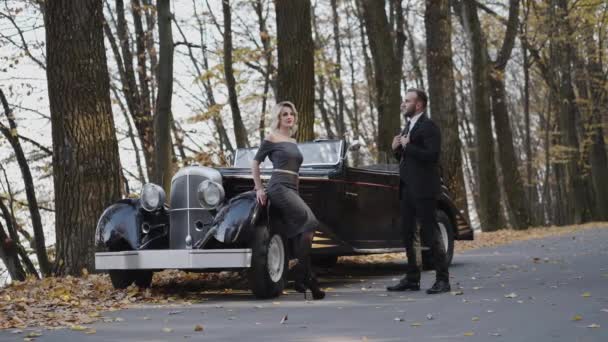 Beau portrait de couple élégant se tient dans des poses à la voiture rétro — Video