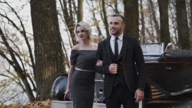 Sevimli, gülümseyen retro çiftin portresi kollarının altında yan yana durur.