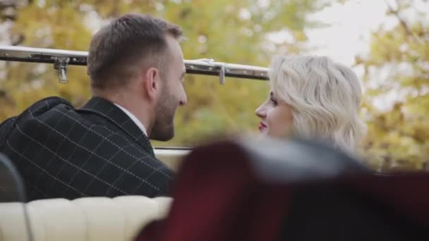 Романтична пара фліртує один з одним з легкою посмішкою в ретро-автомобілі — стокове відео