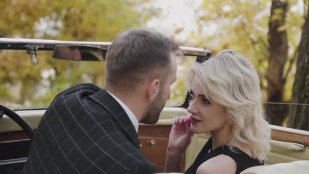 Παθιασμένη ξανθιά με κόκκινα χείλη αγγίζει αρσενικό γενειάδα σε ρετρό αυτοκίνητο — Αρχείο Βίντεο