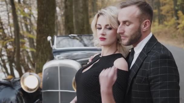 Portrait de couple romantique se tient dans les embrassades et pose à la voiture — Video