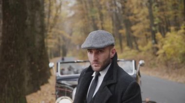 Autumn Park 'taki retro arabadaki yakışıklı, ciddi beyefendinin portresi.