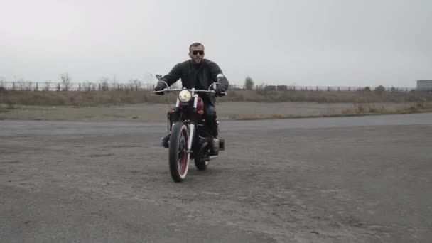 Vista di motociclista brutale in occhiali da sole cavalcando su moto sulla strada — Video Stock