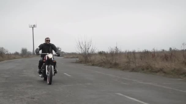 Utsikt över brutal man i solglasögon ridning på motorcykel på motorvägen — Stockvideo