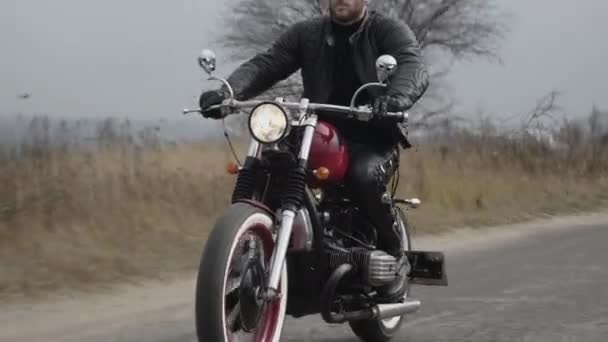 Motocycliste chevauchant rapidement sur la route de campagne et montre les doigts à la caméra — Video