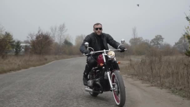 Retrato de motociclista na estrada dirigindo na câmera — Vídeo de Stock