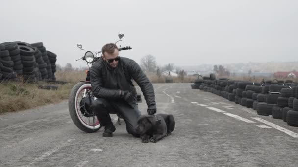 Potrait de motociclista brutal detém buldogue escuro na motocicleta — Vídeo de Stock