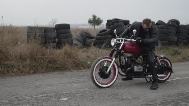 Motocyklista uruchamia i prowadzi motocykl na oponach — Wideo stockowe