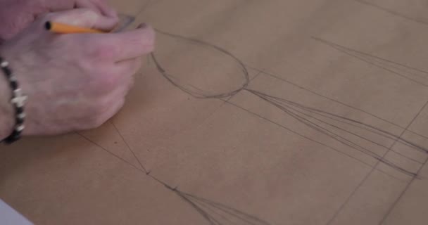 Kleermakers handen meten en tekenen een curve op weefsel op het bureaublad in atelier — Stockvideo